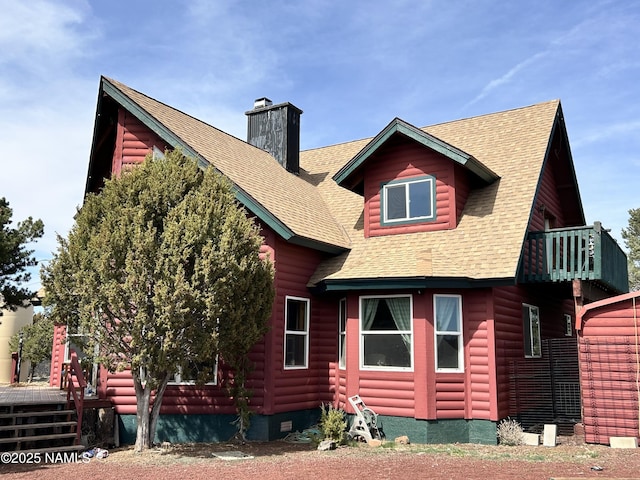 8120 N Cassity Trl, Williams, AZ 86046 - view of side of home with a chimney, a shingled roof, and a balcony