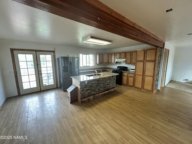 8120 N Cassity Trl, Williams, AZ 86046 - kitchen featuring stainless steel fridge with ice dispenser, black range oven, under cabinet range hood, a sink, and brown cabinetry