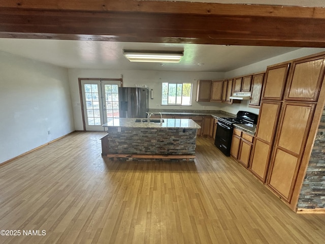 8120 N Cassity Trl, Williams, AZ 86046 - kitchen with black gas range, a sink, stainless steel refrigerator with ice dispenser, and light wood-type flooring
