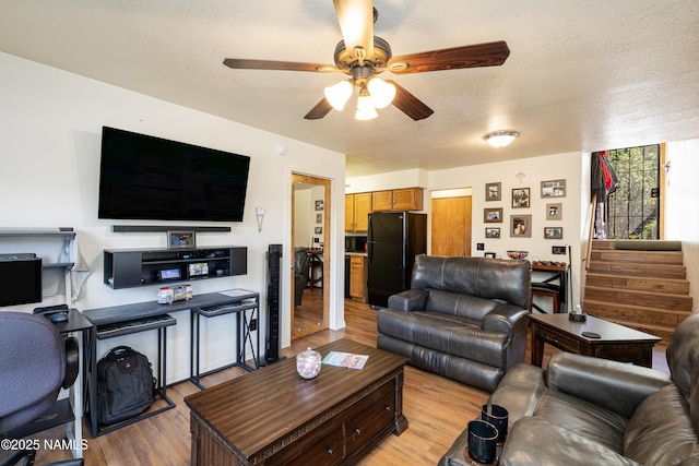 living room featuring a textured ceiling, light hardwood / wood-style flooring, and ceiling fan