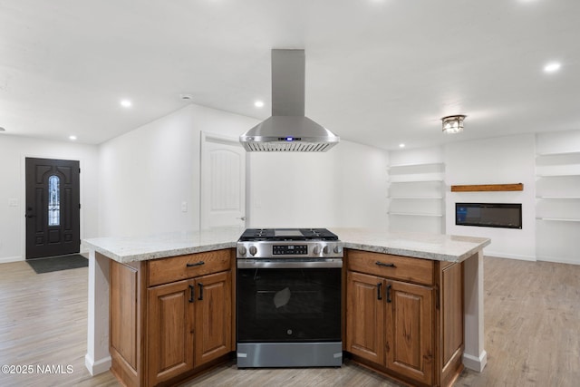 3540 N Walker St, Flagstaff, AZ 86004 - kitchen with light wood finished floors, brown cabinetry, stainless steel gas range, and island range hood