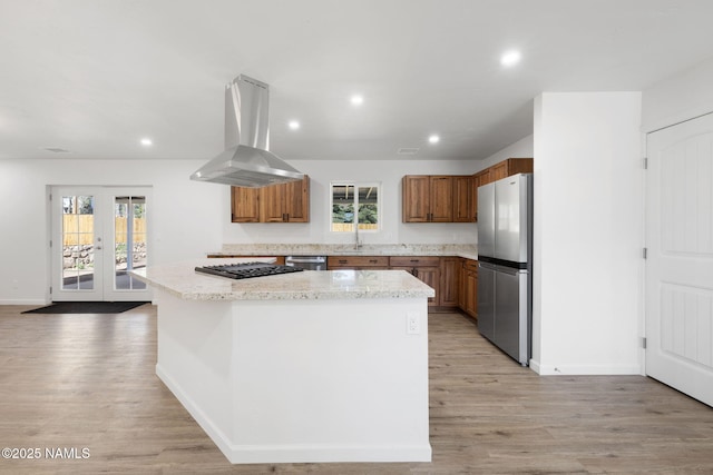 3540 N Walker St, Flagstaff, AZ 86004 - kitchen with light wood finished floors, a center island, appliances with stainless steel finishes, and island range hood