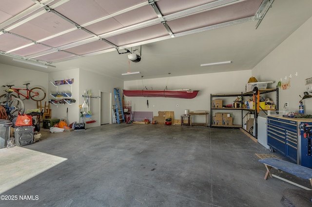 garage with a workshop area and a garage door opener