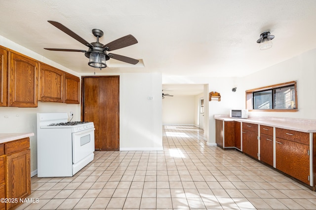 kitchen with ceiling fan, white appliances, and a textured ceiling