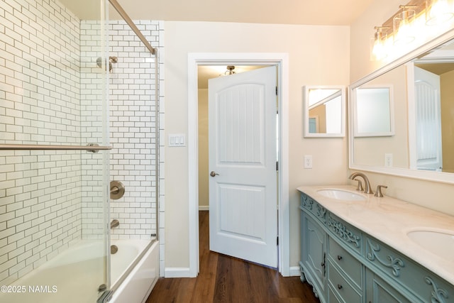 bathroom featuring wood-type flooring, shower / bath combination with glass door, and vanity