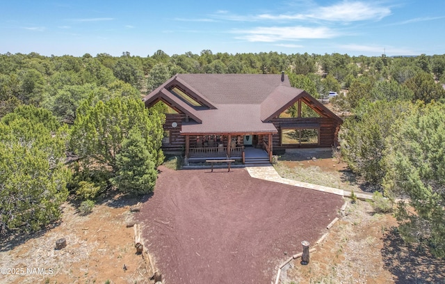 38 Cosnino Rd, Flagstaff, AZ 86004 - log home with log exterior, covered porch, a view of trees, and dirt driveway
