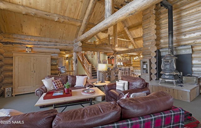 38 Cosnino Rd, Flagstaff, AZ 86004 - carpeted living area with log walls, a wood stove, wooden ceiling with exposed beams, stairway, and high vaulted ceiling