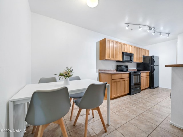 kitchen featuring light tile patterned floors, black appliances, light countertops, and track lighting