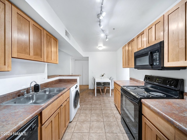 kitchen with light tile patterned floors, a sink, visible vents, black appliances, and washer / dryer