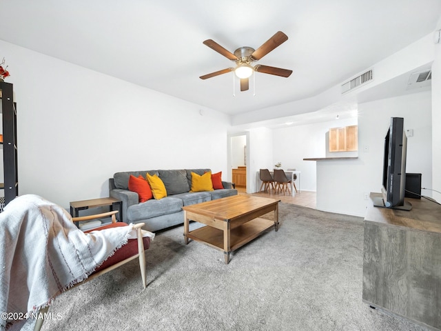 living area featuring carpet floors, visible vents, and a ceiling fan