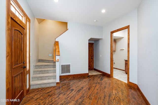 entryway with visible vents, stairs, baseboards, and wood finished floors