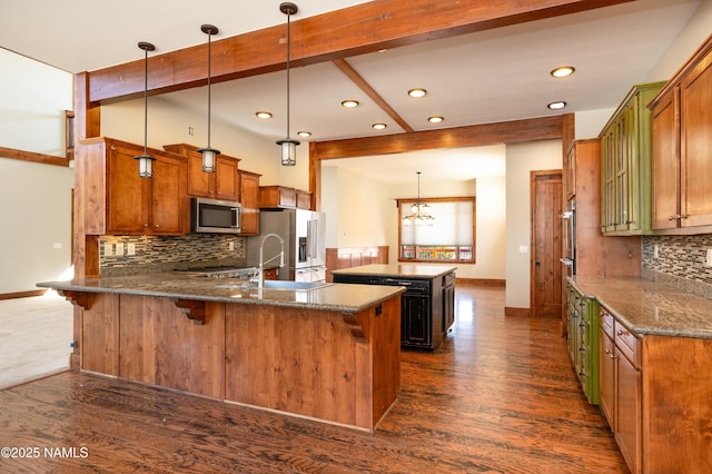 kitchen with a peninsula, a center island, dark wood-type flooring, and stainless steel appliances