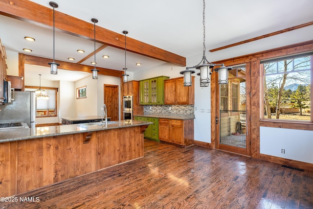 kitchen with beam ceiling, a notable chandelier, a sink, dark wood-style floors, and appliances with stainless steel finishes