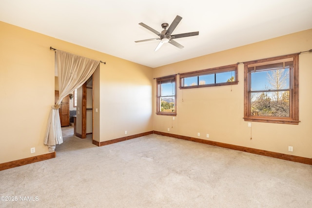 carpeted spare room with baseboards and ceiling fan