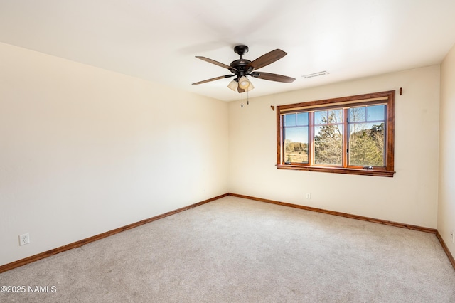 empty room featuring visible vents, light carpet, baseboards, and a ceiling fan