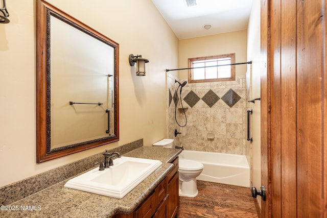 bathroom with vanity, shower / tub combination, toilet, and wood finished floors