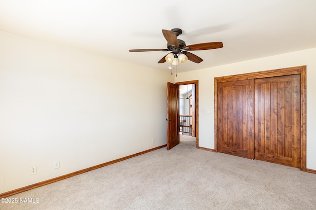 unfurnished bedroom with baseboards, light carpet, and ceiling fan