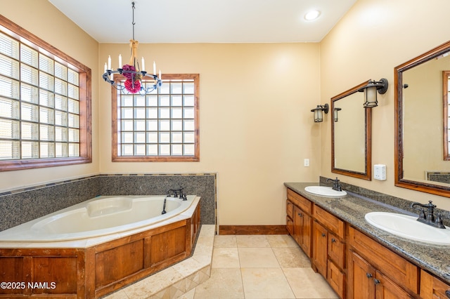 bathroom with an inviting chandelier, tile patterned floors, a bath, and a sink