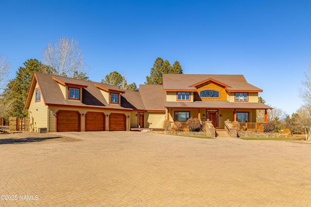 view of front of property with a porch, decorative driveway, and an attached garage