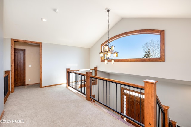 hallway featuring baseboards, carpet floors, an upstairs landing, and vaulted ceiling