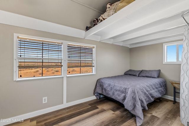 bedroom featuring beamed ceiling, baseboards, and wood finished floors