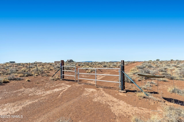 view of gate with a rural view