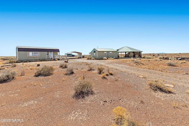 view of front of house with a gazebo, dirt driveway, and a detached carport