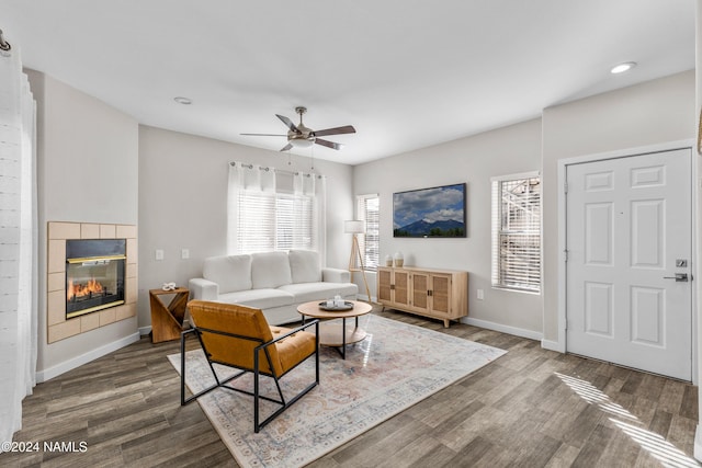 living room with ceiling fan, hardwood / wood-style floors, and a tile fireplace