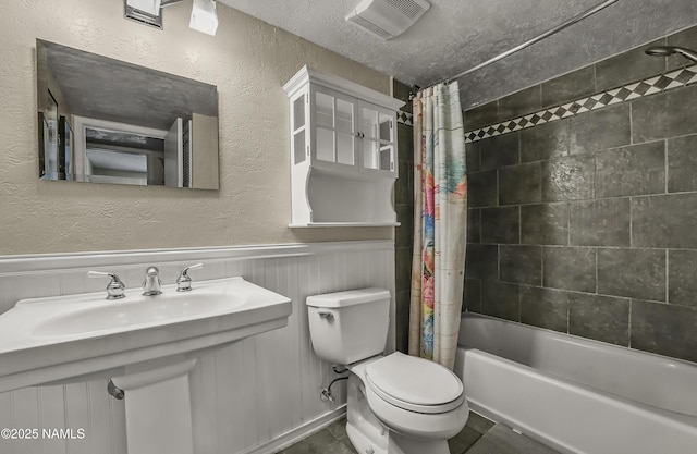 6320 N Mountaineer Rd, Flagstaff, AZ 86004 - bathroom with shower / tub combo, a textured wall, a wainscoted wall, and a textured ceiling