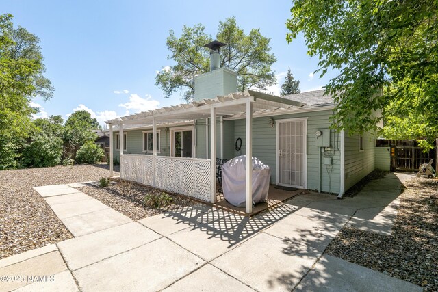 6320 N Mountaineer Rd, Flagstaff, AZ 86004 - rear view of house featuring a patio, a pergola, and a chimney