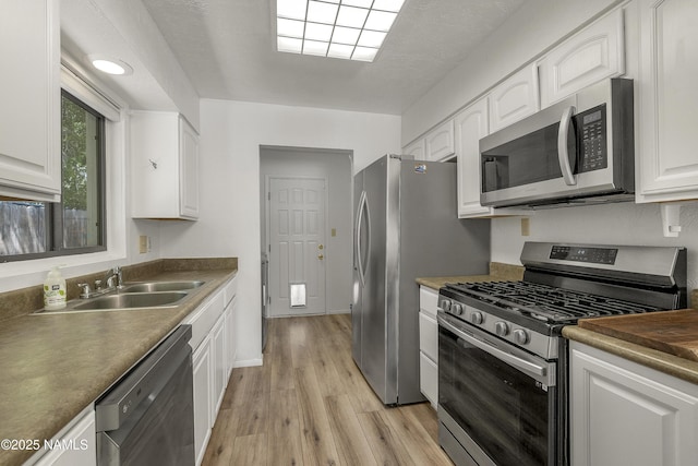 6320 N Mountaineer Rd, Flagstaff, AZ 86004 - kitchen with appliances with stainless steel finishes, white cabinets, and light wood finished floors