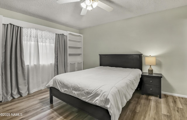 6320 N Mountaineer Rd, Flagstaff, AZ 86004 - bedroom featuring wood finished floors, a textured ceiling, and a ceiling fan
