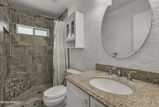 6320 N Mountaineer Rd, Flagstaff, AZ 86004 - full bathroom with a tile shower, vanity, and a textured wall