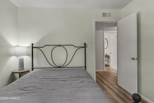 6320 N Mountaineer Rd, Flagstaff, AZ 86004 - bedroom with wood finished floors and a textured ceiling