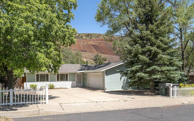 6320 N Mountaineer Rd, Flagstaff, AZ 86004 - view of front facade featuring a garage, a fenced front yard, and driveway