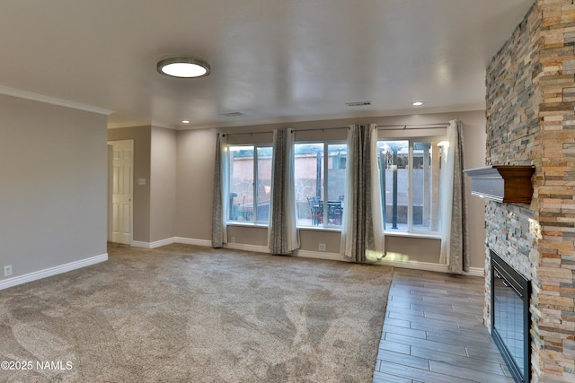 unfurnished living room featuring a stone fireplace, recessed lighting, visible vents, baseboards, and ornamental molding