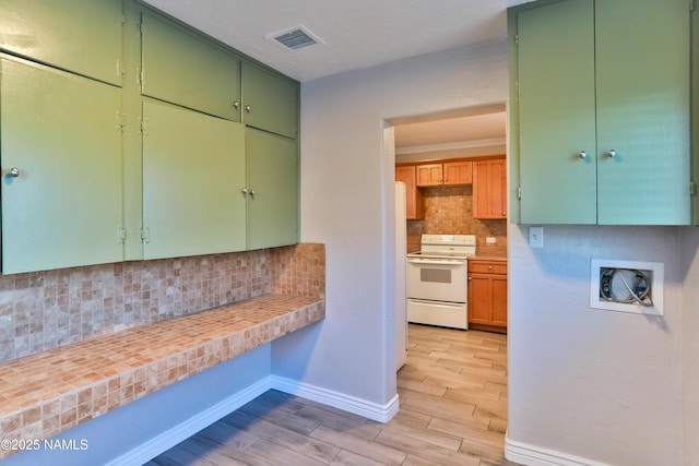 kitchen with visible vents, wood tiled floor, light countertops, white electric range, and backsplash