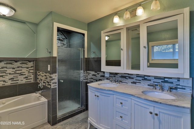 full bathroom with a stall shower, a garden tub, a sink, and double vanity