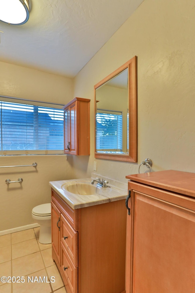 bathroom with toilet, tile patterned flooring, and vanity