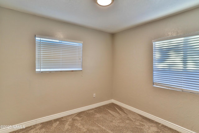 empty room with carpet and baseboards