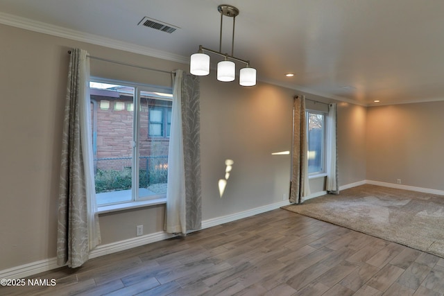 foyer featuring baseboards, visible vents, wood finished floors, and ornamental molding