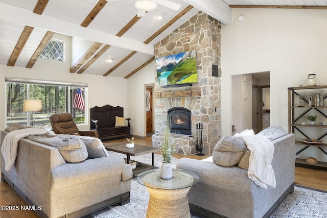 7530 N Rain Valley Rd, Flagstaff, AZ 86004 - living area with wood finished floors, high vaulted ceiling, a stone fireplace, a ceiling fan, and wood ceiling with exposed beams