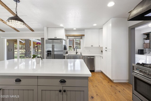 7530 N Rain Valley Rd, Flagstaff, AZ 86004 - kitchen with stainless steel appliances, separate washer and dryer, a sink, light countertops, and white cabinets