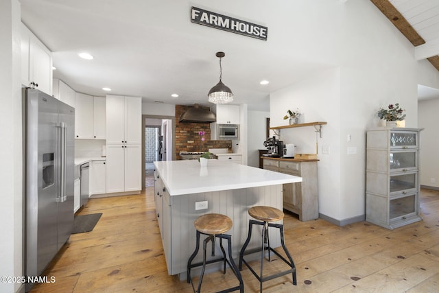 7530 N Rain Valley Rd, Flagstaff, AZ 86004 - kitchen with stainless steel appliances, light wood-style floors, exhaust hood, a center island, and beamed ceiling