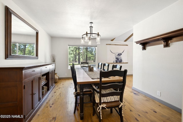 7530 N Rain Valley Rd, Flagstaff, AZ 86004 - dining space featuring a chandelier, light wood-style floors, and baseboards