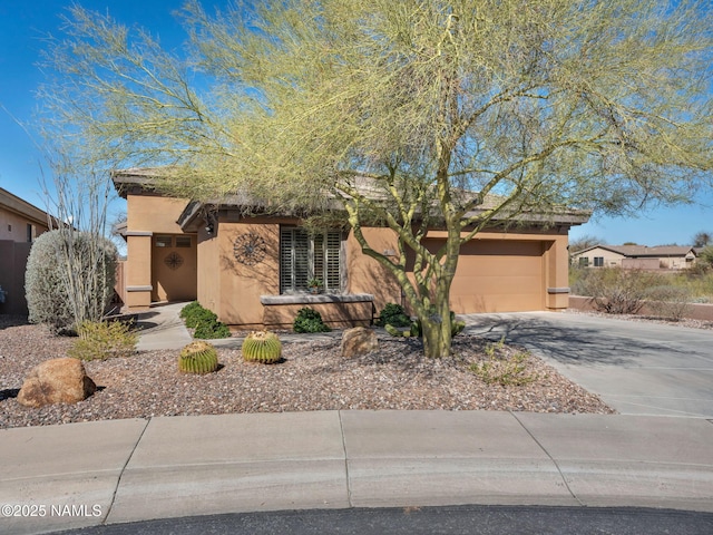 view of front of house with a garage, concrete driveway, and stucco siding