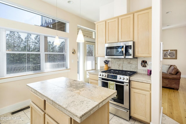 673 N Pine Cliff Dr, Flagstaff, AZ 86001 - kitchen featuring light brown cabinetry, appliances with stainless steel finishes, decorative backsplash, and visible vents