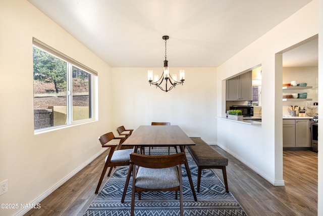 dining room with dark wood-style floors, baseboards, and an inviting chandelier