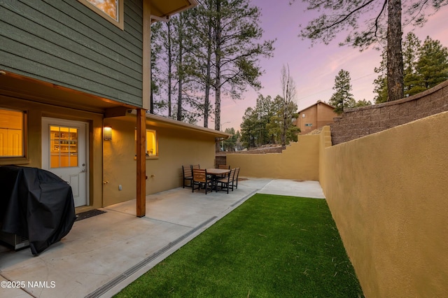 yard at dusk with a patio area and fence