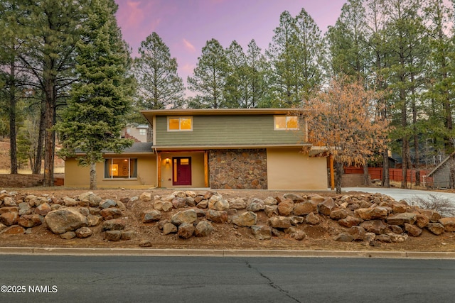 view of front of house with driveway and stone siding